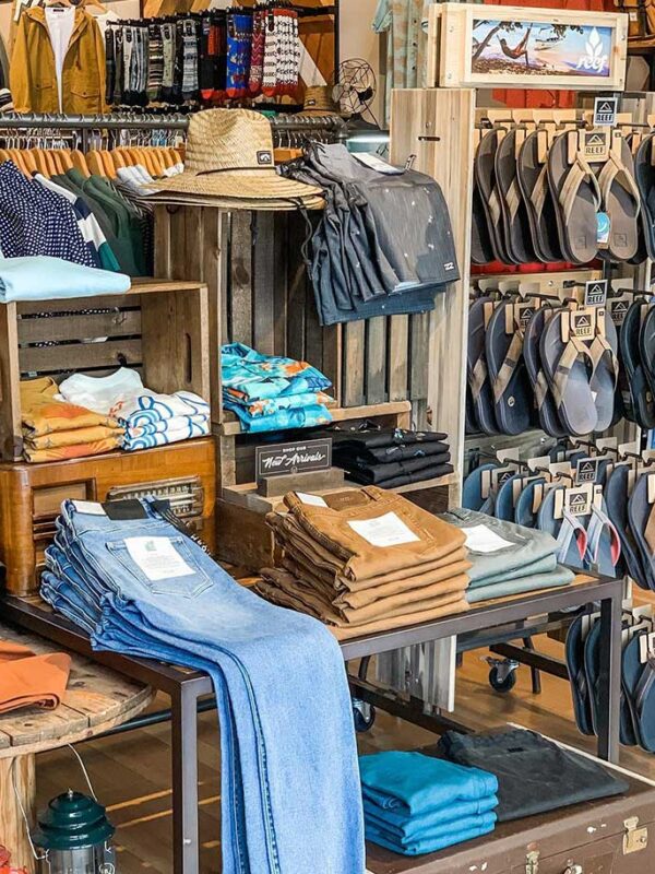 A retail space with jeans, sandals, shirts and hats