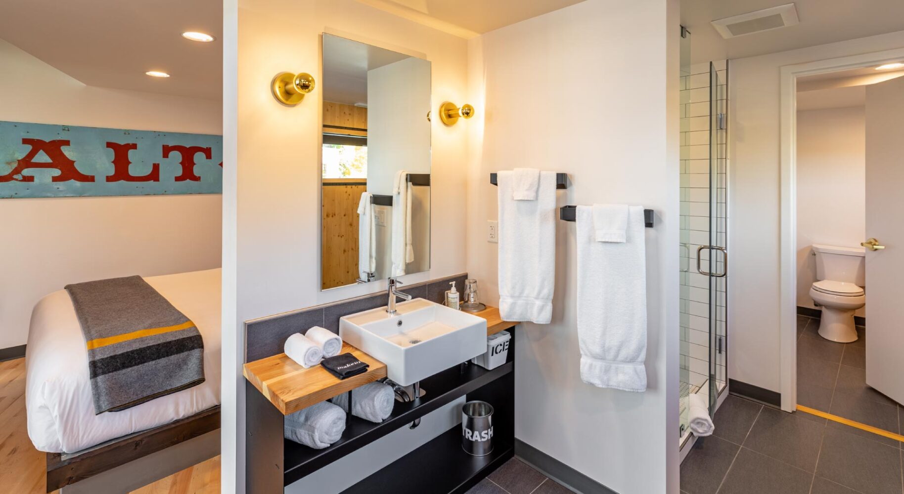 http://Interior%20view%20of%20the%20bathroom%20in%20our%20downtown%20Bozeman%20hotel%20room%20suite.%20Small%20vanity,%20white%20walls,%20and%20walk%20in%20shower